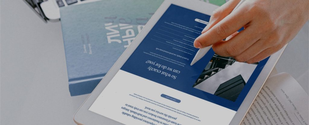 Home Close-up of a hand using a stylus on a tablet displaying a corporate services webpage