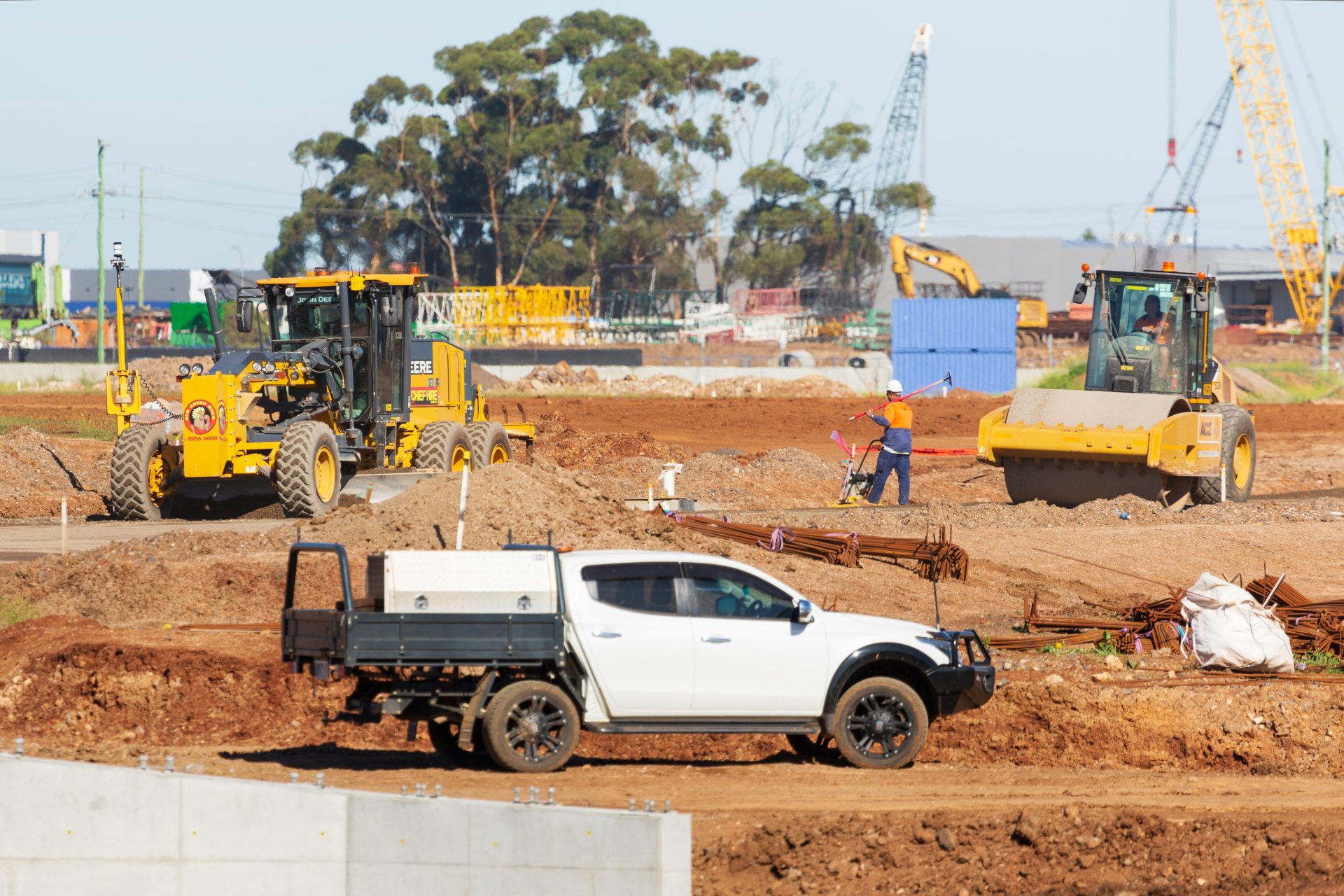 Grader, roller and work ute on a construction site
