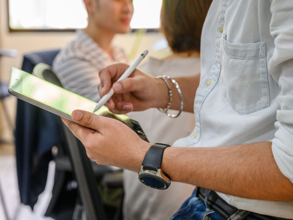 Adviser taking notes on a tablet during a meeting